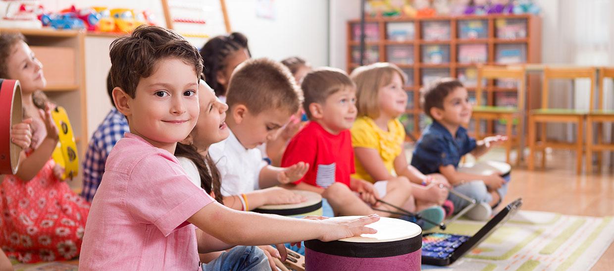 Group of children playing drums and other music instruments