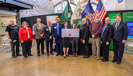 A picture of 11 people representing Global Foundries and Hudson Valley Community College. The two people in the center hold a large check to represent the donation.